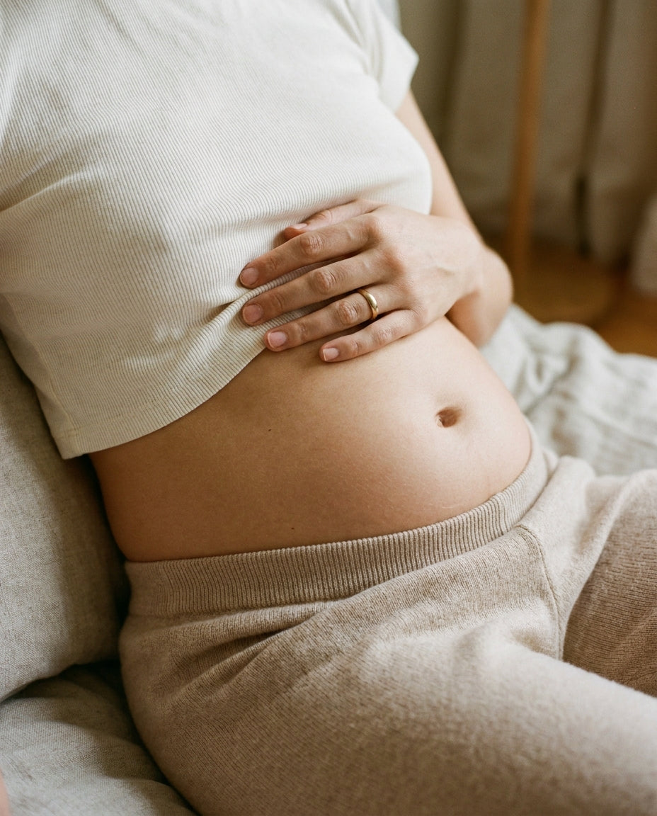 Woman cradling her stomach, feeling bloated and uncomfortable